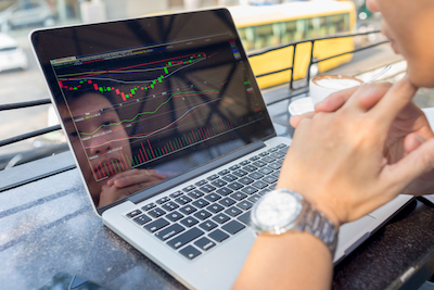 Open laptop with data and reflection of user's face.