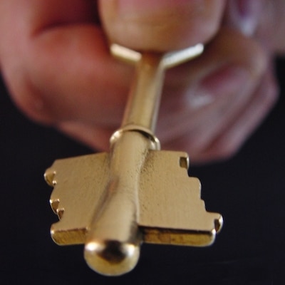 Image of a golden key held in hand