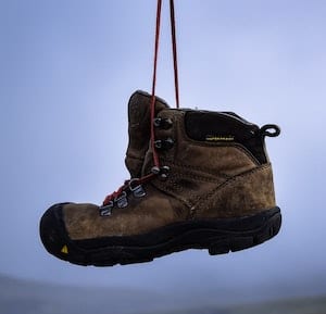 Image of a boot hanging by the laces in air