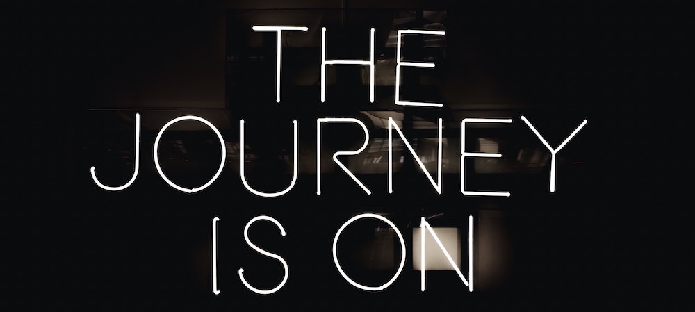 Neon image of text: The Journey Is On