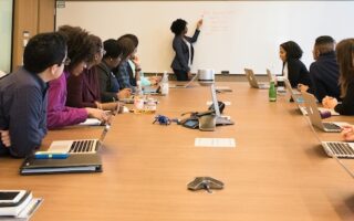 Business meeting in a conference room with leader at whiteboard