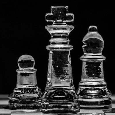 3 glass chess pieces on a board
