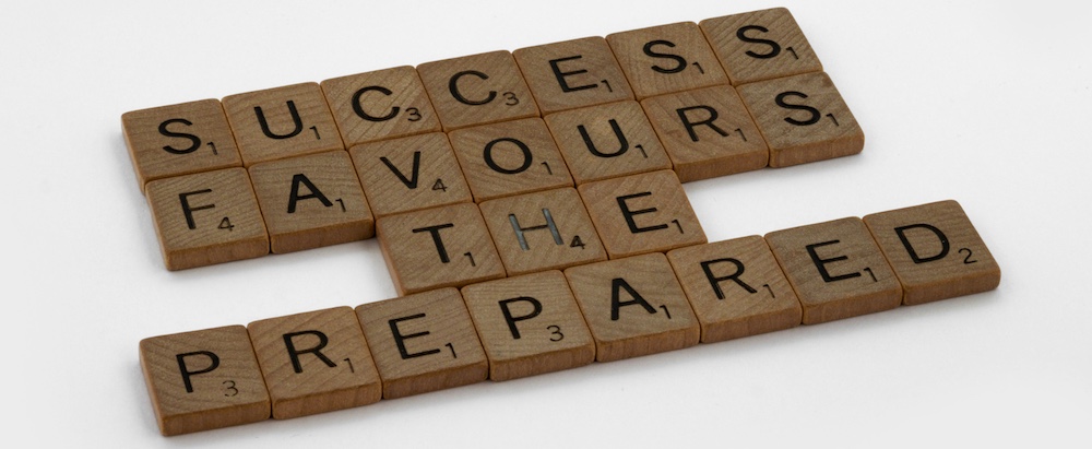 Wooden tiles with letters spelling out Success Favors The Prepared