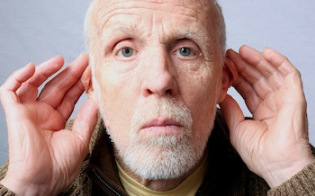 Image of a man's head while he holds his hands to his ears to listen better